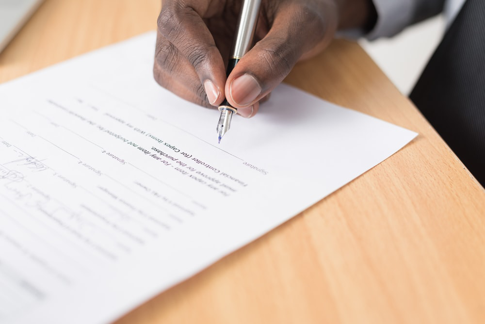 a person signing a company form which is a common practice in the West